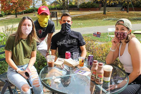 四名足球外围买球靠谱的学生戴着口罩，在足球外围盘官方网站外面一起闲逛